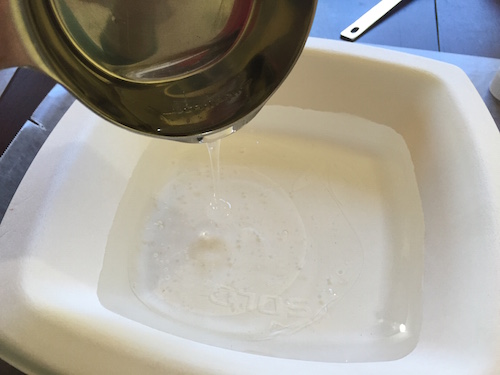 pouring glue into a bowl filled with water
